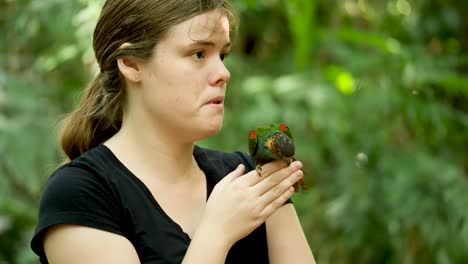 Loro-Verde,-Loro-Conure-De-Garganta-Azul-Sentado-En-La-Mano-Humana-Y-El-Loro-Volador-Libre-De-La-Cabeza-Sentado-Sentado-En-El-Loro-Volador-Humano-Libre-Jugando-Con-Una-Niña