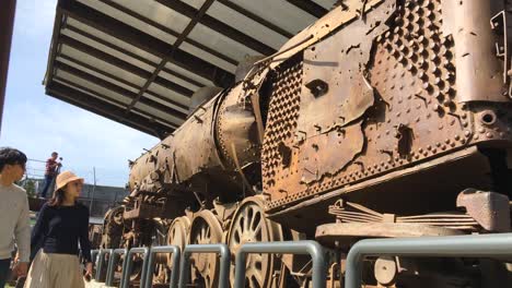 A-couple-of-lovers-watch-the-wreckage-of-a-train-bombed-during-the-Korean-war-displayed-at-Imjingak-by-the-DMZ-overlooking-North-Korea,-in-Munsan,-Paju,-Gyeonggi-do,-South-Korea