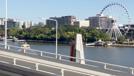 El-Ferry-Cat-De-La-Ciudad-De-Brisbane-Sale-De-La-Terminal-Del-Muelle-Norte-Hacia-El-Banco-Sur-Con-La-Rueda-De-Brisbane-En-El-Fondo