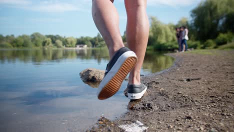 Caminar-Por-La-Orilla-De-Un-Lago-Y-Saltar-Sobre-Una-Roca