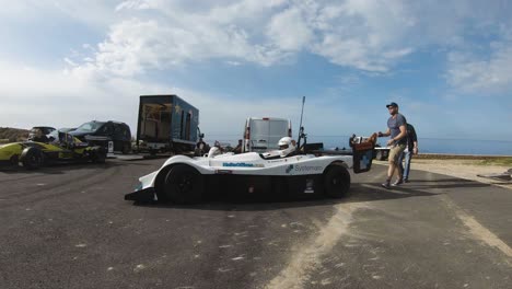 Hombre-Empujando-Un-Coche-De-Carreras-Blanco-Para-Arrancar-El-Motor-En-La-Colina-En-Imtahleb-Malta-En-Un-Día-Soleado---Gopro-Pan-Shot