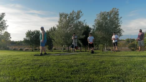 Jungs,-Die-Abwechselnd-Ihre-Scheiben-Auf-Einem-Discgolfplatz-Werfen