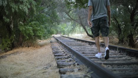 Toma-En-Cámara-Lenta-De-Alguien-Caminando-Sobre-Vías-De-Tren-Abandonadas