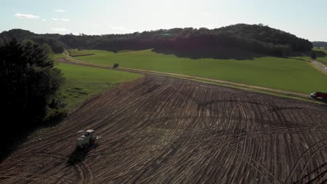 4K-Luftlandschaftsansicht-Einer-Erntemaschine,-Die-Nach-Der-Ernte-Durch-Ein-Fertiges-Feld-Fährt