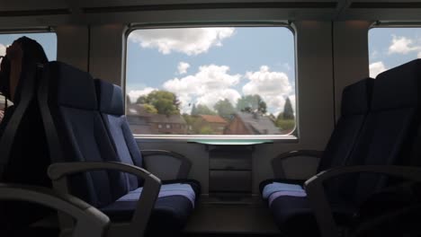 View-of-countryside-on-sunny-summer-day-through-silhouetted-train-window