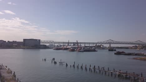 Aerial-Over-Abandoned-Piers-With-Maurice-J-Tobin-Memorial-Bridge-In-The-Background,-Boston