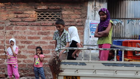 Local-Indian-children-playing,-acting-shy-in-streets-Kerala,-India