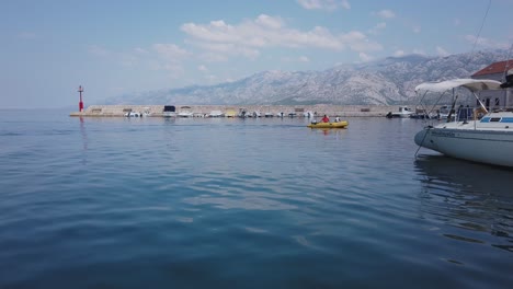 Leuchtend-Gelbes-Aufblasbares-Motorboot-Fährt-In-Den-Yachthafen-Des-Kroatischen-Dorfes-Ein