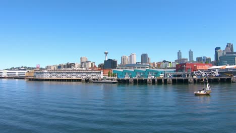 Navegando-En-Un-Bote-Con-Vista-Al-Puerto-Y-A-La-Ciudad-De-Seattle-Y-Un-Pequeño-Bote-Navegando-En-El-Agua-Sirface