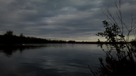 Dark,-moody-time-lapse-of-people-crossing-a-floating-bridge,-set-against-a-quick-moving-ominous-sky