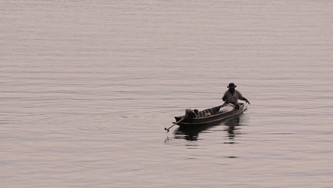 Pescador-Perfilando-Mientras-Lanza-Y-Saca-Su-Red-En-El-Río-Antes-Del-Anochecer,-En-Cámara-Lenta