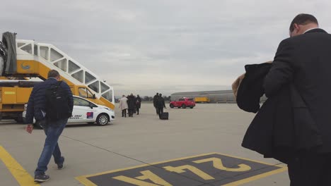 POV-people-board-aircraft-on-tarmac-at-international-airport,-overcast