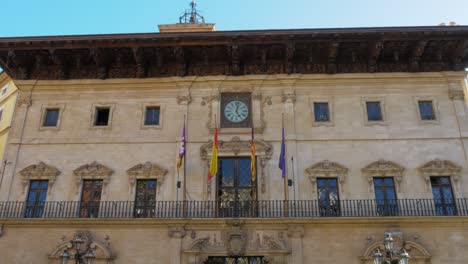 Edificio-Con-Banderas-Europeas-Colgando-En-Una-Fila-Debajo-Del-Reloj