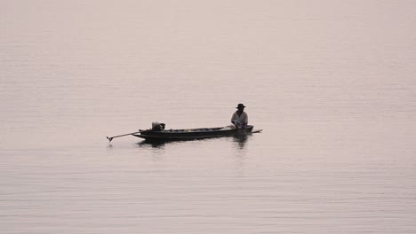 Pescador-Perfilando-Mientras-Lanza-Y-Saca-Su-Red-En-El-Río-Antes-Del-Anochecer,-En-Cámara-Lenta