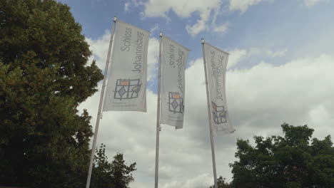 Tres-Banderas-De-Schloss-Johannisburg-En-El-Asta-De-La-Bandera-Ondeando-En-El-Viento-En-Un-Hermoso-Día-De-Verano