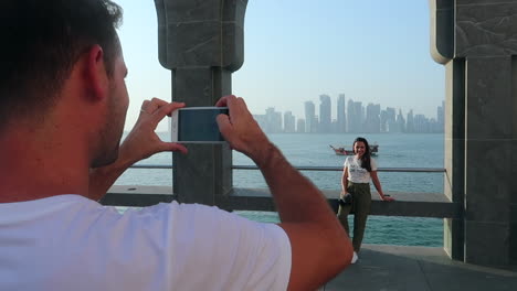 Pareja-Tomando-Fotos-De-Vacaciones-En-Doha-Qatar-Con-El-Horizonte-De-La-Ciudad-En-El-Fondo