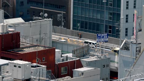 Rooftop-view-and-traffic-on-a-background-street-in-the-downtown-area-in-slow-motion,-Stable-high-view-shot