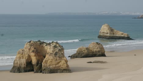 Hombre-Y-Perro-Caminando-Solos-Cerca-De-Formaciones-Rocosas-Playa-De-Rocas-Portimão