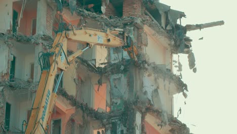 Vista-De-Una-Excavadora-Con-Una-Pluma-Larga-Demoliendo-Un-Edificio-De-Gran-Altura