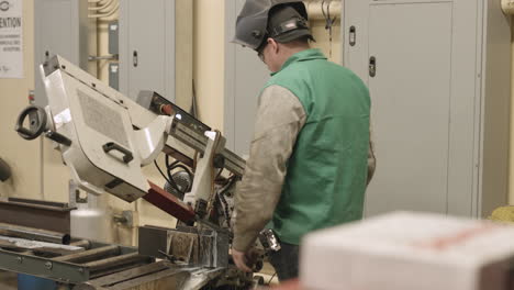 Trade-school-student-uses-an-industrial-cutting-tool-to-cut-a-piece-of-steel