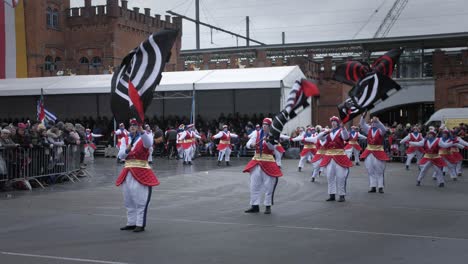 Big-dancer-group-in-Aalst-carnival-parade-and-at-front-of-the-group-performers-waving-big-flags