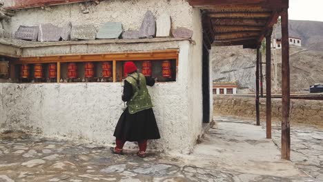 Una-Anciana-Caminando-Y-Girando-Las-Ruedas-De-Oración-En-El-Monasterio-De-Lamayuru