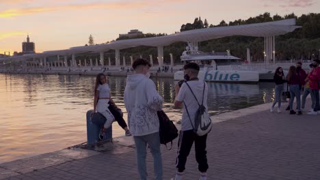 Tourists-on-Europe-Vacation-Taking-Pictures-in-Malaga,-Spain-at-Sunset