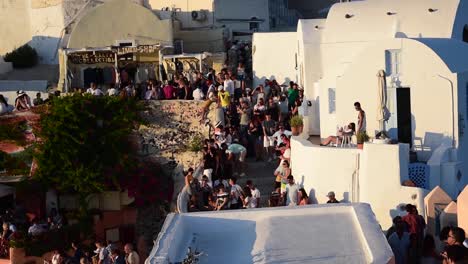 The-beautiful-village-of-Oia-crowded-full-of-tourists-for-the-sunset,-Santorini-island,-Greece