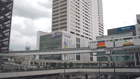 Ein-Vorbeifahrender-Einschienenbahnzug-Mit-Der-Skyline-Der-Innenstadt-Im-Hintergrund-In-Tokio,-Japan