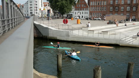 Statische-Aufnahme-Von-Der-Brücke,-Die-Menschen-Zeigt,-Die-An-Einem-Sonnigen-Tag-In-Der-Lübecker-Altstadt-Kajak-Paddeln