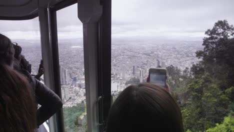 A-woman-taking-pictures-on-her-smartphone-of-the-view-of-Bogotá-city