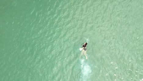 Direkt-Oben-Blick-Auf-Eine-Frau,-Die-Im-Kristallklaren-Wasser-Des-Karibischen-Meeres-Schwimmt