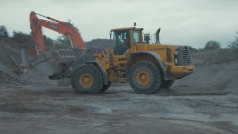 Wheel-loader-driving-right-to-left-bucket-full-with-gravel-quarry-4K