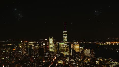 Toma-Panorámica-Aérea-Que-Muestra-Fuegos-Artificiales-Sobre-El-Horizonte-De-La-Ciudad-De-Nueva-York-Por-La-Noche-Durante-La-Celebración-Del-Año-Nuevo