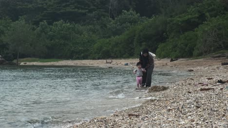 Mujer-Islamista-Con-Burka-Y-Niño-Pequeño-Jugando-En-La-Orilla-De-Una-Playa-Rocosa-En-Malasia