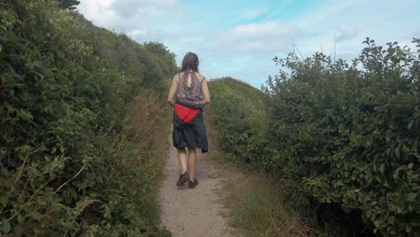 Señorita-Caminando-Por-El-Sendero-Costero-Del-Acantilado-En-Torquay,-Revelando-El-Océano-Y-Los-Acantilados