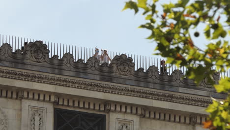 View-from-the-ground-of-tourists-wearing-protective-face-masks-on-the-roof-of-the-Arc-de-Triomphe-Paris