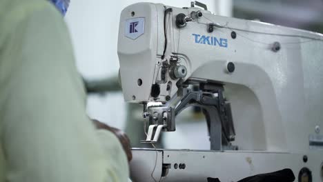 Máquina-De-Coser-De-Funcionamiento-Del-Trabajador-De-La-Explotación-En-La-Fábrica-De-Fabricación-De-Ropa-De-Diseñador