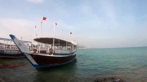 Un-Barco-Tradicional-De-Madera-Con-Vista-En-Qatar-Se-Conoce-Como-Dhow,-Ofrece-Paseo-A-Los-Pasajeros-Por-5-$-Por-Persona-En-Corniche-En-Doha,-Qatar