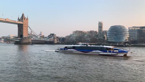 Ein-Blick-Auf-Die-Themse-Und-Eine-Sehr-Schnelle-Fähre,-Die-Voller-Touristen-Vor-Der-Tower-Bridge-Herunterfährt