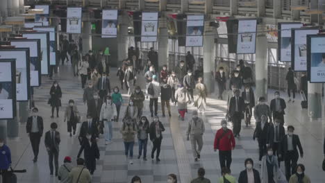 Digital-Screens-Playing-Ads-Mounted-On-Ceiling-Of-Shinagawa-JR-Station-With-Commuters-During-Pandemic-In-Tokyo,-Japan