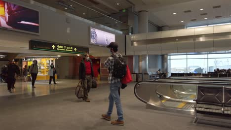 Reisende-Tragen-Am-Flughafen-Eine-Gesichtsmaske