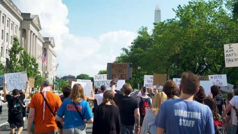 Marchers-holding-BLM-signs-as-they-pass-by-the-Washington-Monument