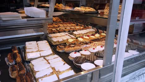 Looking-at-delicious-cakes-display-in-Conwy-cake-shop-window-display