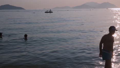 People-enjoying-the-evening-at-Repulse-Bay-beach-in-Hong-Kong-as-public-beaches-reopening,-after-months-of-closure-amid-coronavirus-outbreak,-to-the-public