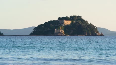 Langsamer-Zoom-Auf-Die-Burg-„Fort-De-Brégançon“,-Ferienresidenz-Der-Französischen-Präsidenten-Bei-Sonnenuntergang,-Wellen-Im-Vordergrund