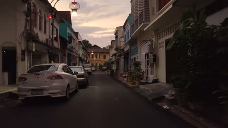 Volando-Entre-Edificios-En-Una-Calle-Vacía-Al-Atardecer