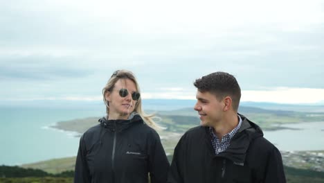 Joven-Pareja-Atractiva-Caminando-En-La-Cima-De-Una-Colina-En-Bluff-Nueva-Zelanda---Primer-Plano-Frontal