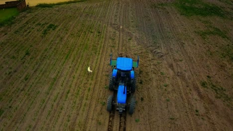 Toma-Aérea-De-Pájaros-De-Un-Tractor-Arando-Un-Campo-De-Cultivo-En-América-Del-Sur