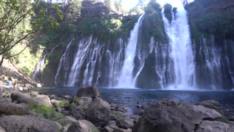 4K-Aufnahmen-Von-Burney-Falls,-Mit-Einem-Mann,-Der-In-Der-Linken-Unteren-Ecke-Im-Eiskalten-Wasser-Hin--Und-Herschwimmt